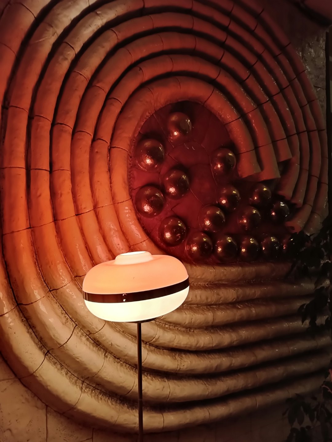 Moderne Lampe beleuchtet eine strukturierte Wand mit welligen Rillen.
